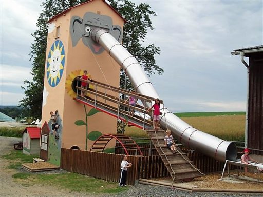 Ein spielerischer Spielplatz mit einem Elefantenrutschen und Klettergerüst.